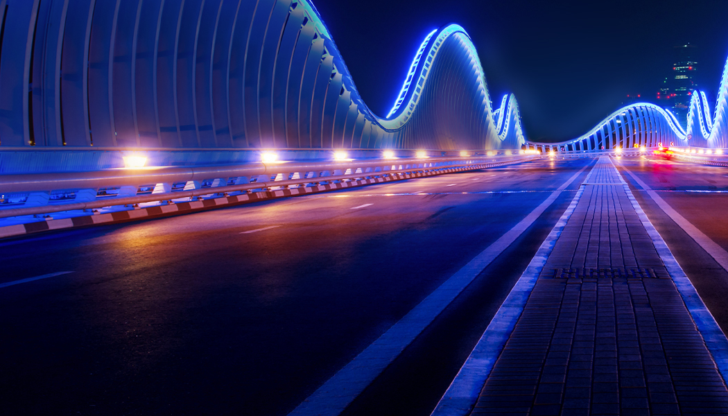 A nicely lighted Bridge in neon lights. 