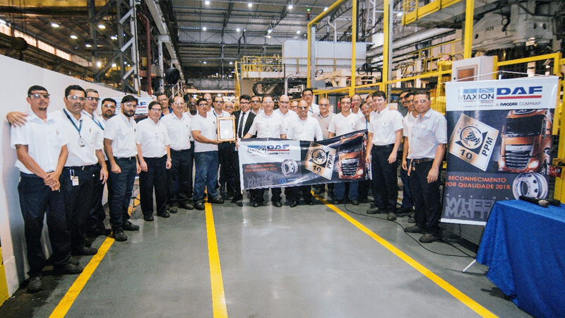 A large group of Maxion employees in a factory building.