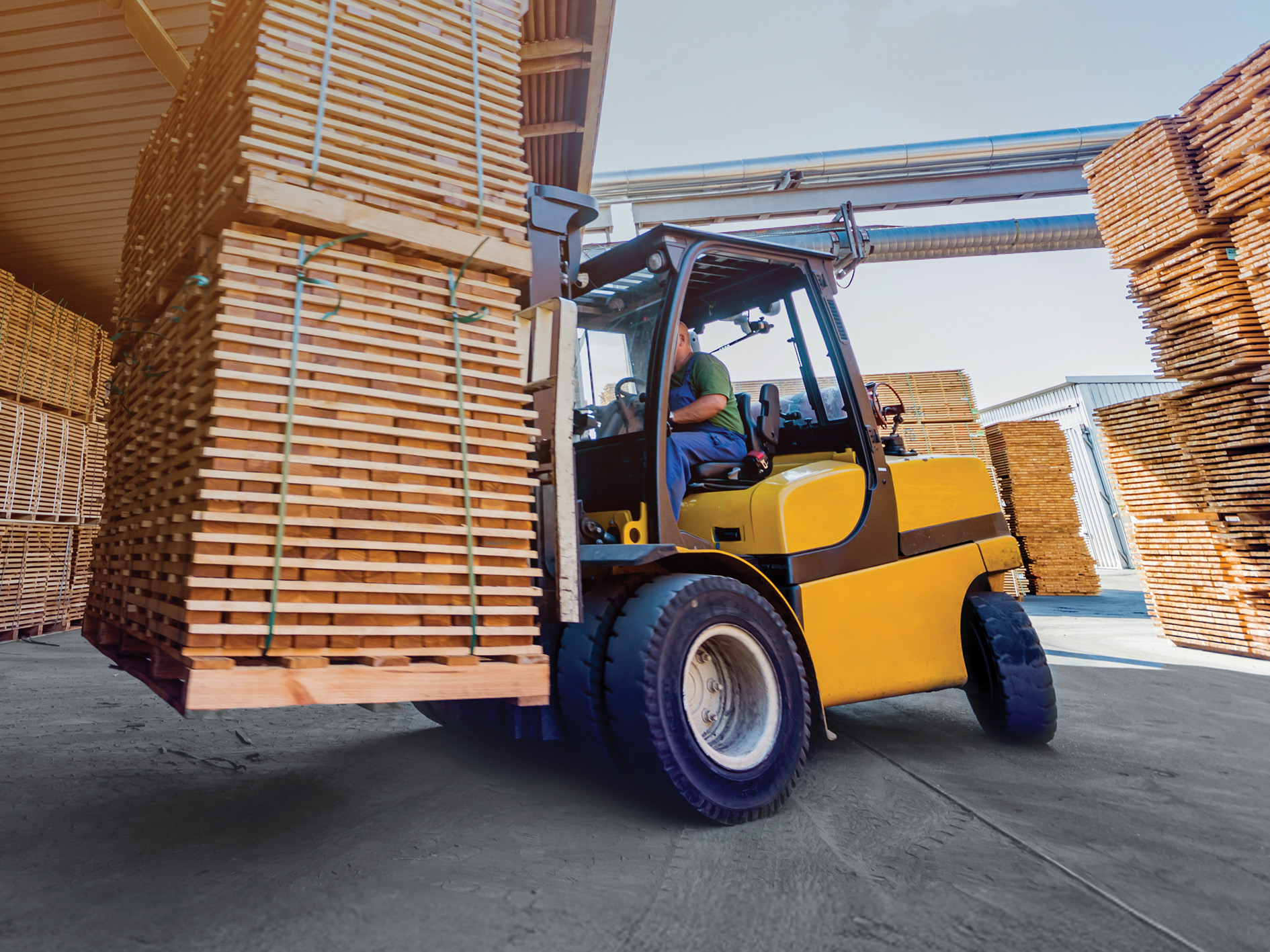 yellow forklift moving wood pallets outdoor