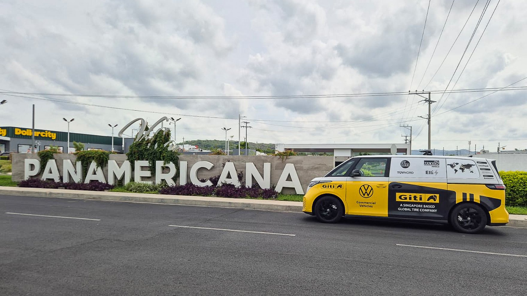 yellow Volkswagen van parked on an asphalt street next to large white 3D letters spelling Panamericana