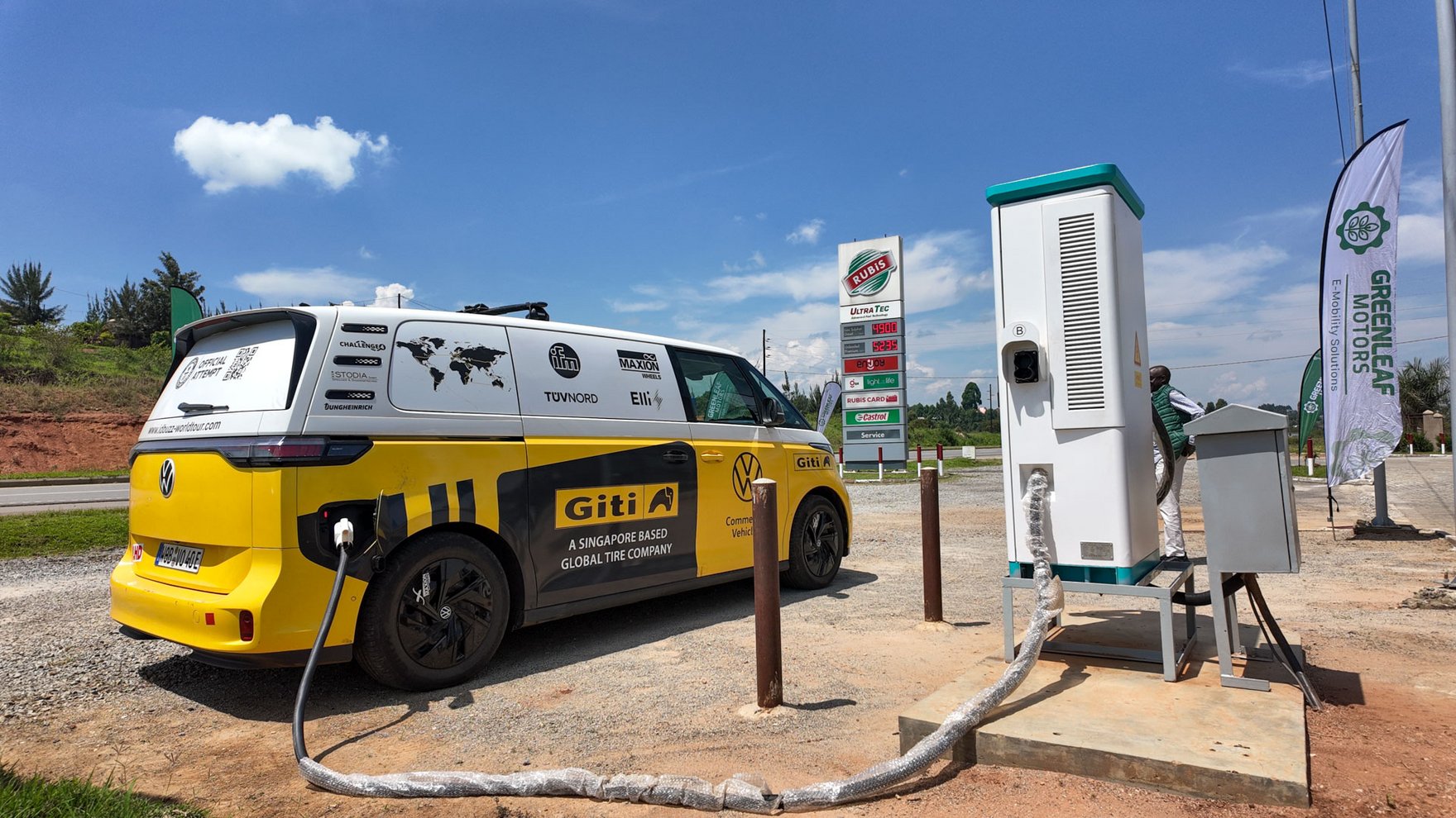 A yellow and white electric VW ID bus is charging on an outdoor charging station