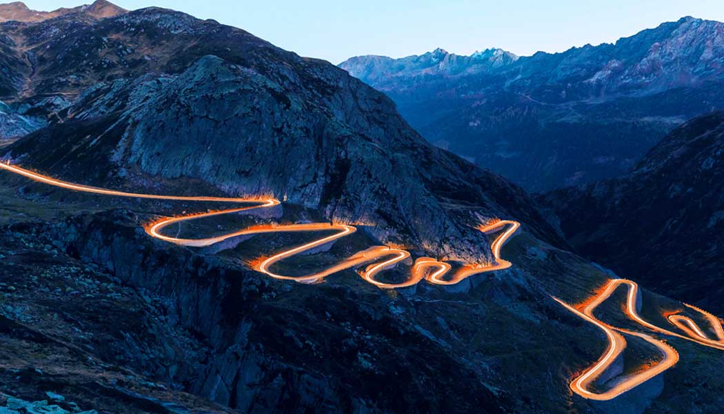 Long Exposure of car with lights driving up a winding road.